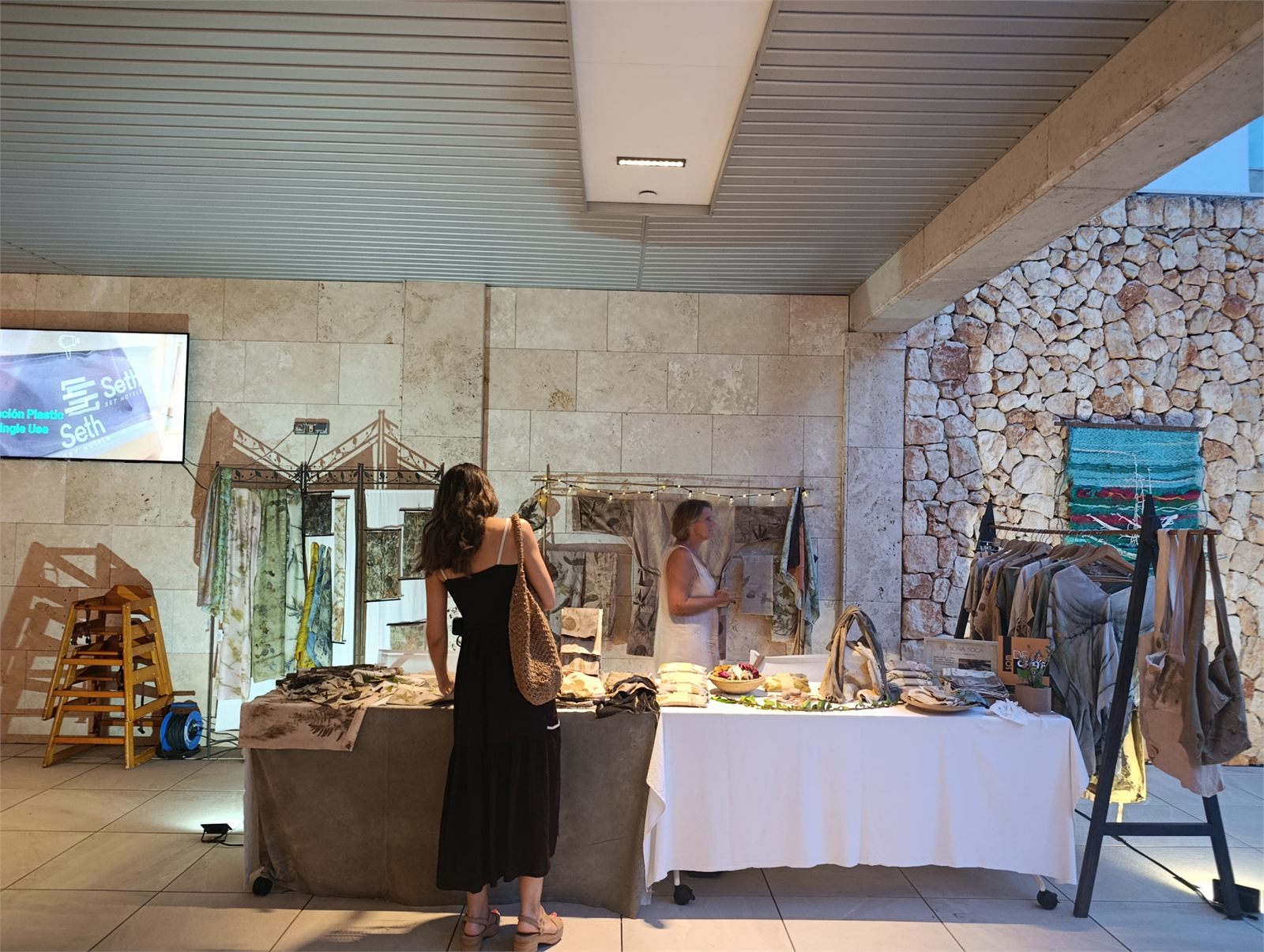 Taules amb peces artesanals i visitants a Essència Artesanal